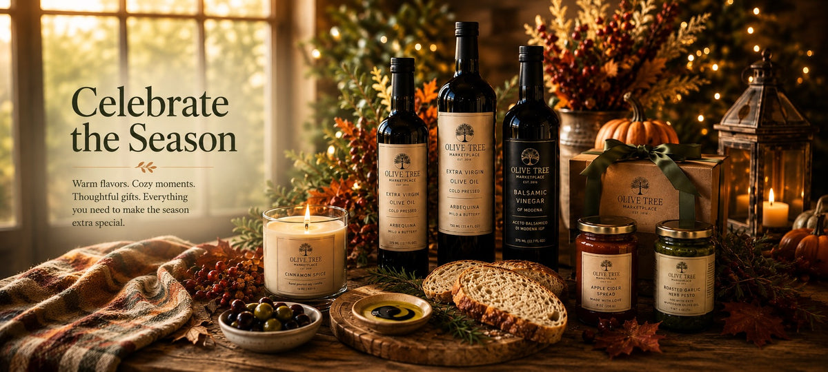 Olive Tree Marketplace autumn collection — olive oils, balsamic vinegars, preserves and a lit soy candle among pumpkins, autumn leaves and cranberries